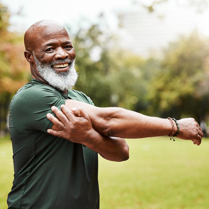 African American senior man stretching in park