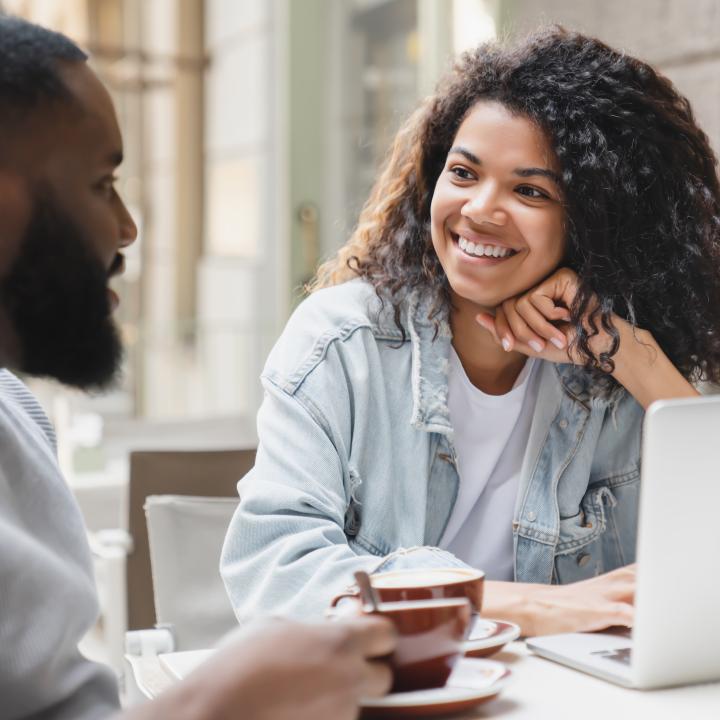 African American couple having friendly conversation at coffee shop