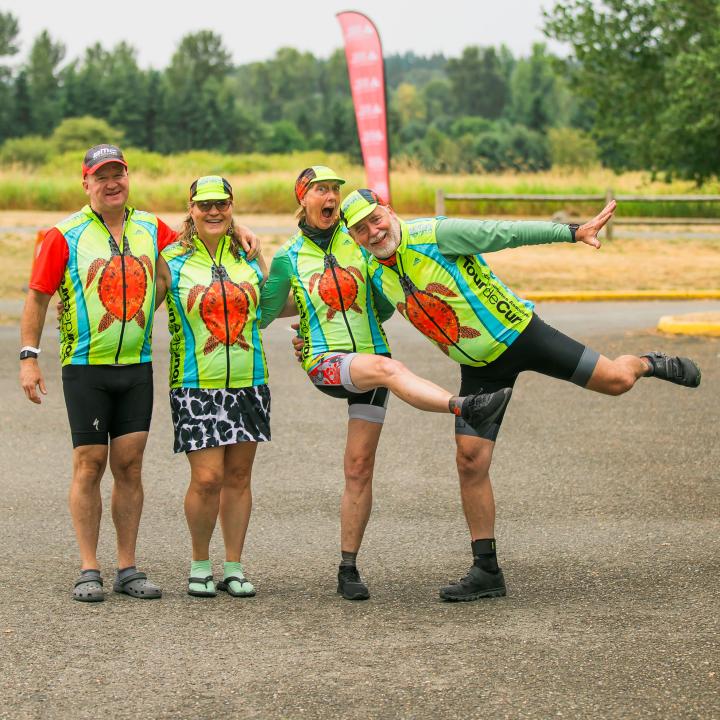 Happy group of bike riders in green turtle shirts