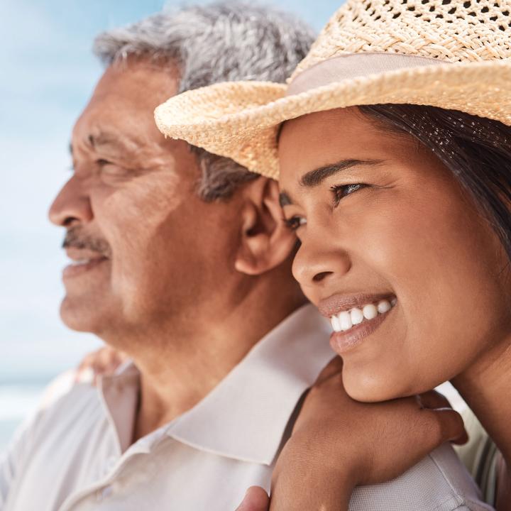 Senior latino father and daughter at the beach