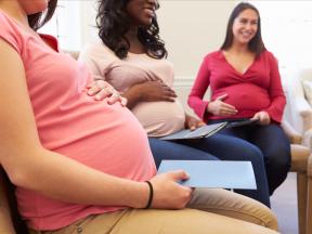 Multiple pregnant women sitting in a room together