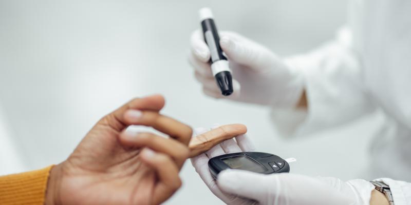 Close-up of person getting blood glucose tested with lancet