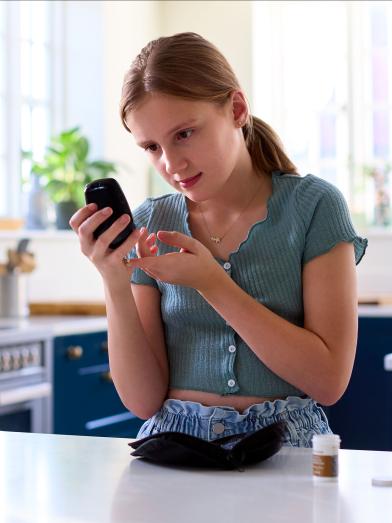 Young girl checking her blood glucose with meter